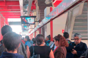 personas viendo televisión digital en tren suburbano